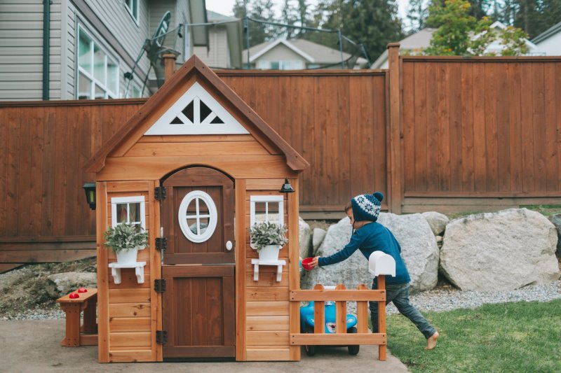 Ein Junge spielt mit einem Kinder-Spielhaus